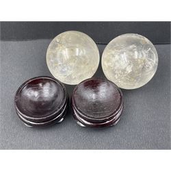 Pair of quartz spheres, upon carved wooden stands, D4cm