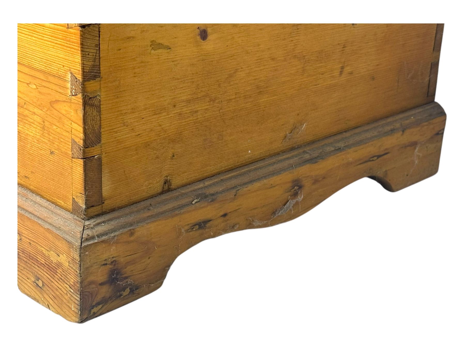 Late 19th century stripped pine blanket box, rectangular hinged lid enclosing main compartment with fitted candle box, wrought iron strap hinges and lock, black-painted side handles, on a shaped plinth base