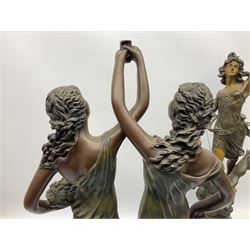 Pair of spelter figures, comprising male and female both stood upon an eagle, on stepped circular bases, together with composite sculpture of two females holding a cup between them, tallest example 64cm