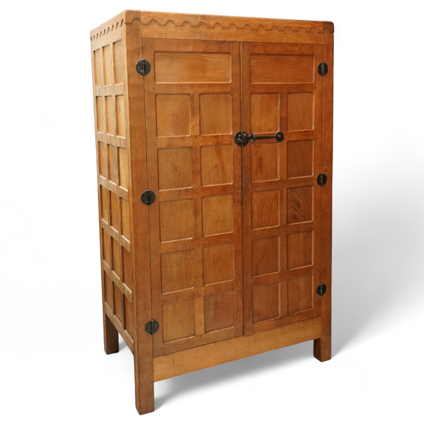 Mouseman - Oak 5' x 3' wardrobe, circa 1950s, scalloped cornice, panelled sides and front, twin doors with wrought metal latch and hinges, raised on stile supports with carved mouse to left hand side, by the workshop of Robert Thompson, Kilburn

Provenance - this lot comes to us for sale from direct descent of Robert Thompson. Thompson is the great grandfather of the vendor.
