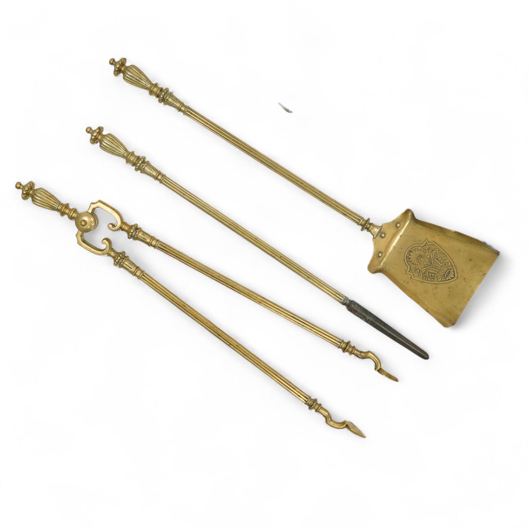 19th century brass and iron fire dogs with fire irons, the fire dogs each with urn finials and arched legs, accompanied by three brass fire tools including shovel, poker and tongs with matching turned handles