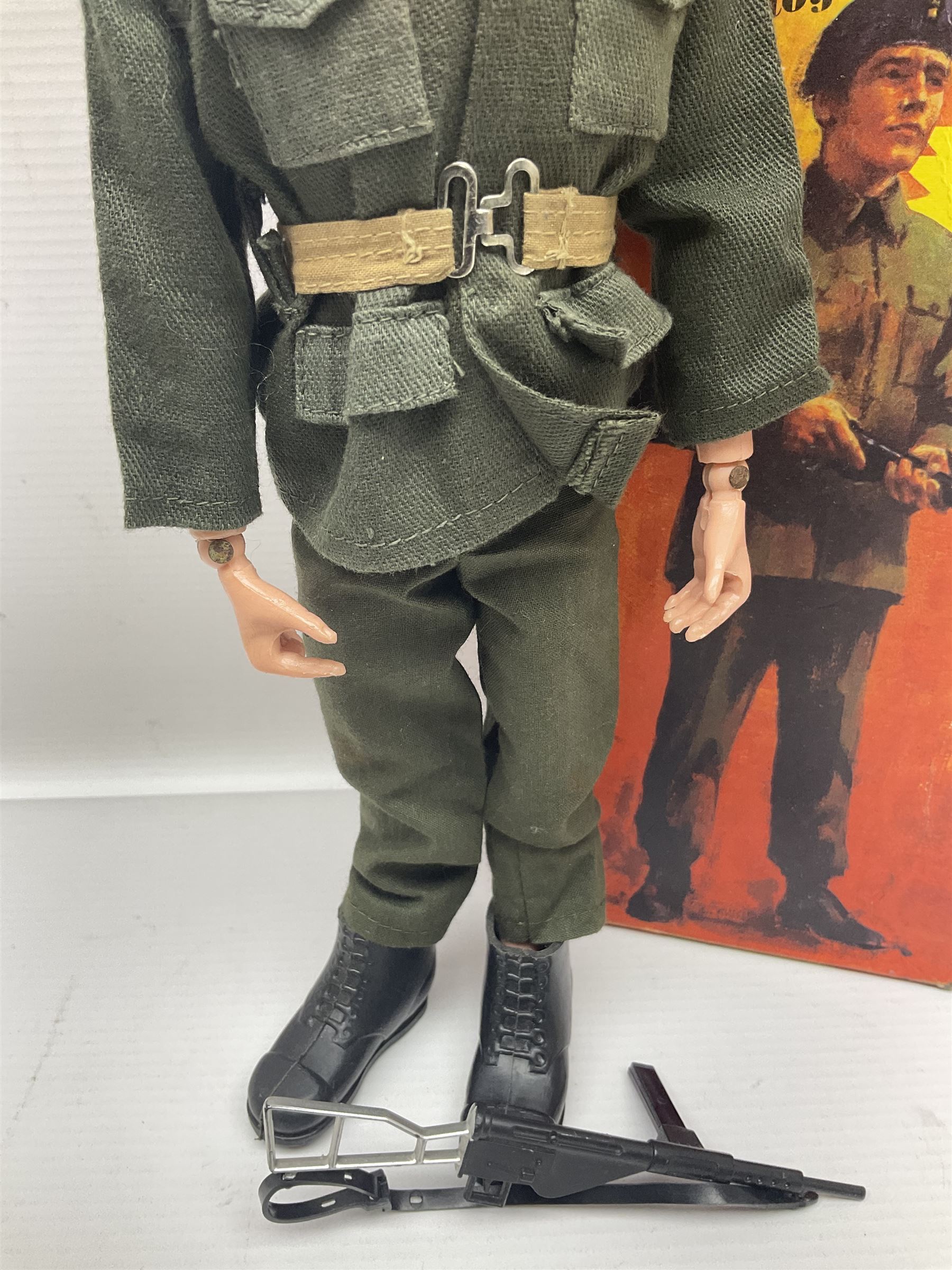Palitoy Action Man Action Soldier No.34014 with tunic, belt, trousers, boots, blue beret and sten gun; in original box; and Palitoy Action Man Royal Military Policeman (RMP) gripping hands figure, marked 'Made in England by Palitoy under licence from Hasbro © 1964' to rear of torso; with tunic, shirt, trousers, tie, boots, belt, truncheon, pistol in holster, MP armband, red cap, Sterling machine gun and other clothing etc; in anrelated display box (2)