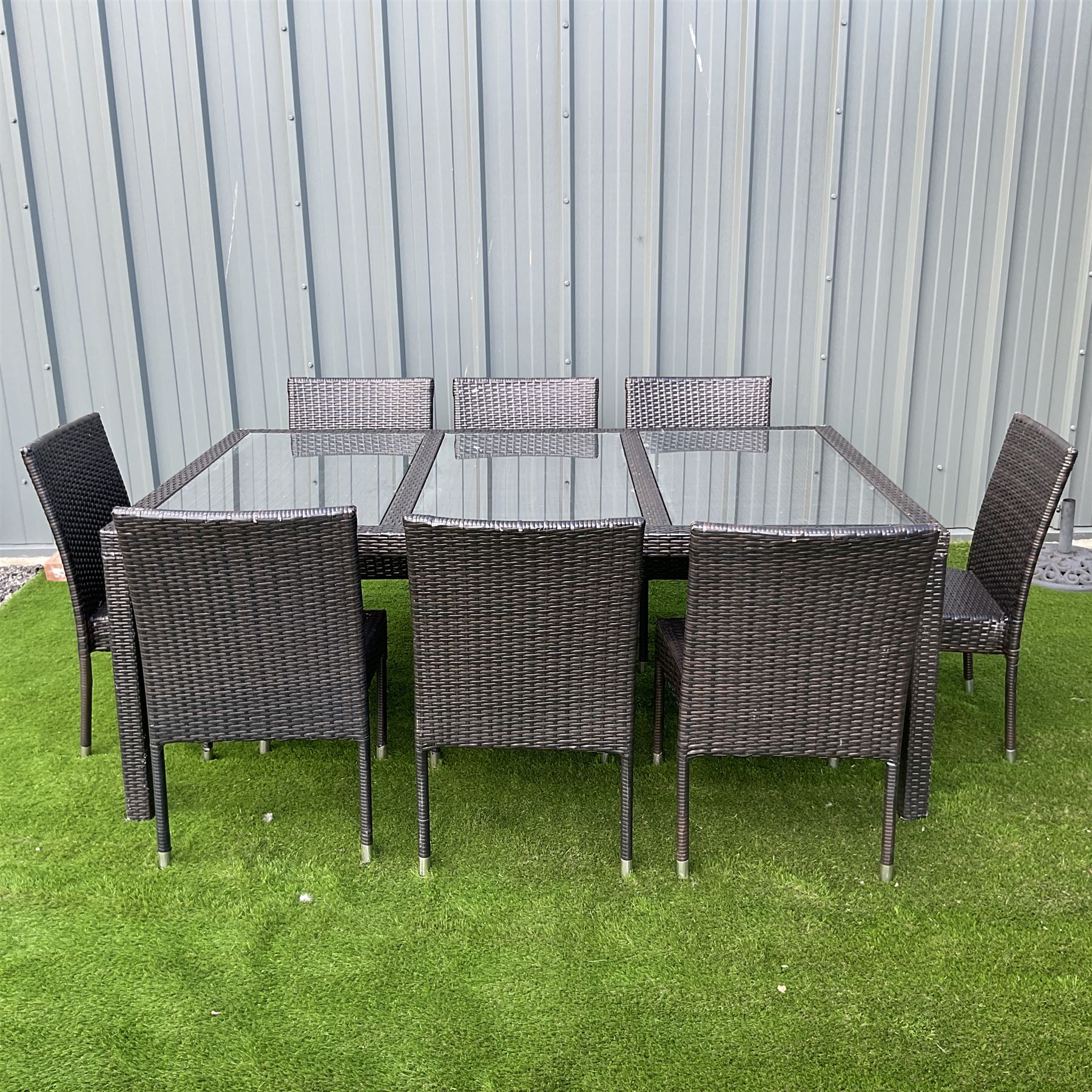 Grey rattan garden table with three glass inlays and eight chairs