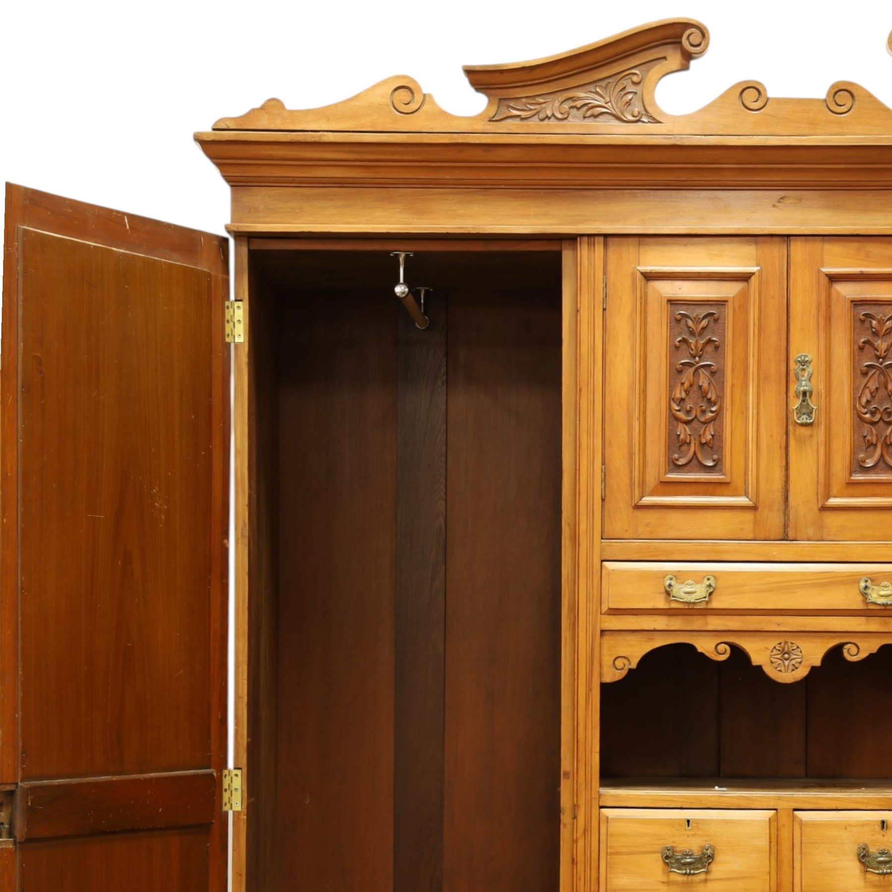 Edwardian walnut triple combination wardrobe, projecting pediment with pierced foliate scroll cresting above a central cupboard flanked by bevelled mirrored doors, over open recess with mirrored back, above two short and three long drawers with brass handles, interior fitted with hanging rails and shelf, raised on plinth base