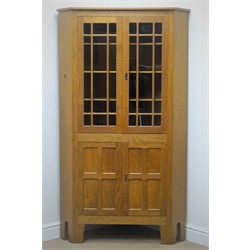  Yorkshire Oak - 'Acornman' corner cabinet, two astragal glazed doors, fitted with three shaped shelves, above two panelled doors, by Alan Grainger of Brandsby, York, W95cm, H169cm  