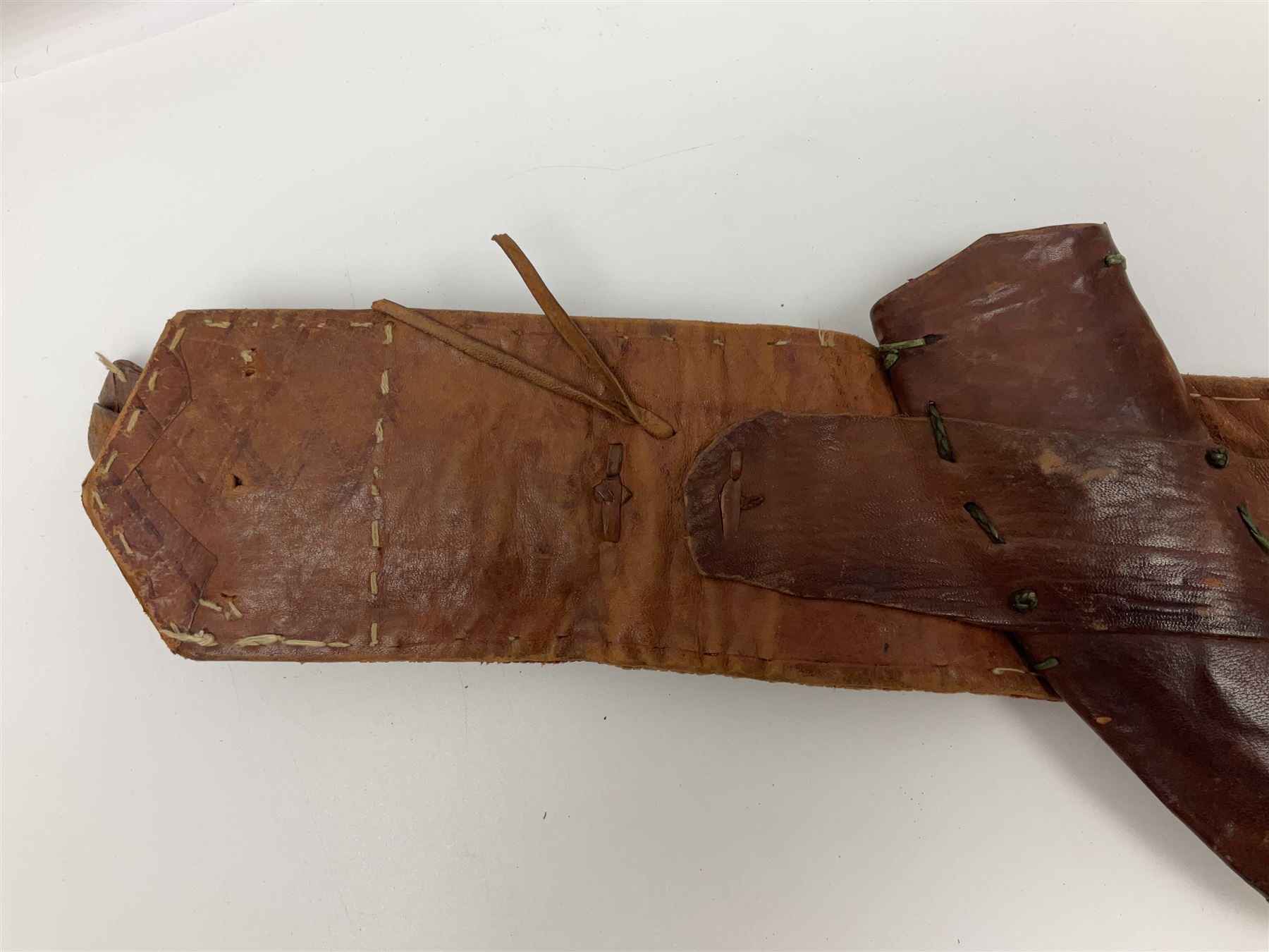 Late 19th century Yemeni Tuza jambiya as worn by religious elite, the 20.5cm curving blade with raised medial ridge, the horn hilt with pique style studwork, in a leather wrapped wooden scabbard with pierced metal mount and leather belt applied with embroidered 'gold' and 'silver' thread work panel; dagger L36cm overall, belt L84cm