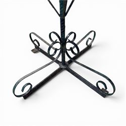 Matched pair of antique metal plant stands, each with circular strapwork basket tops, the scrollwork supports raised on an X-form base, in green painted finish with rustic patina