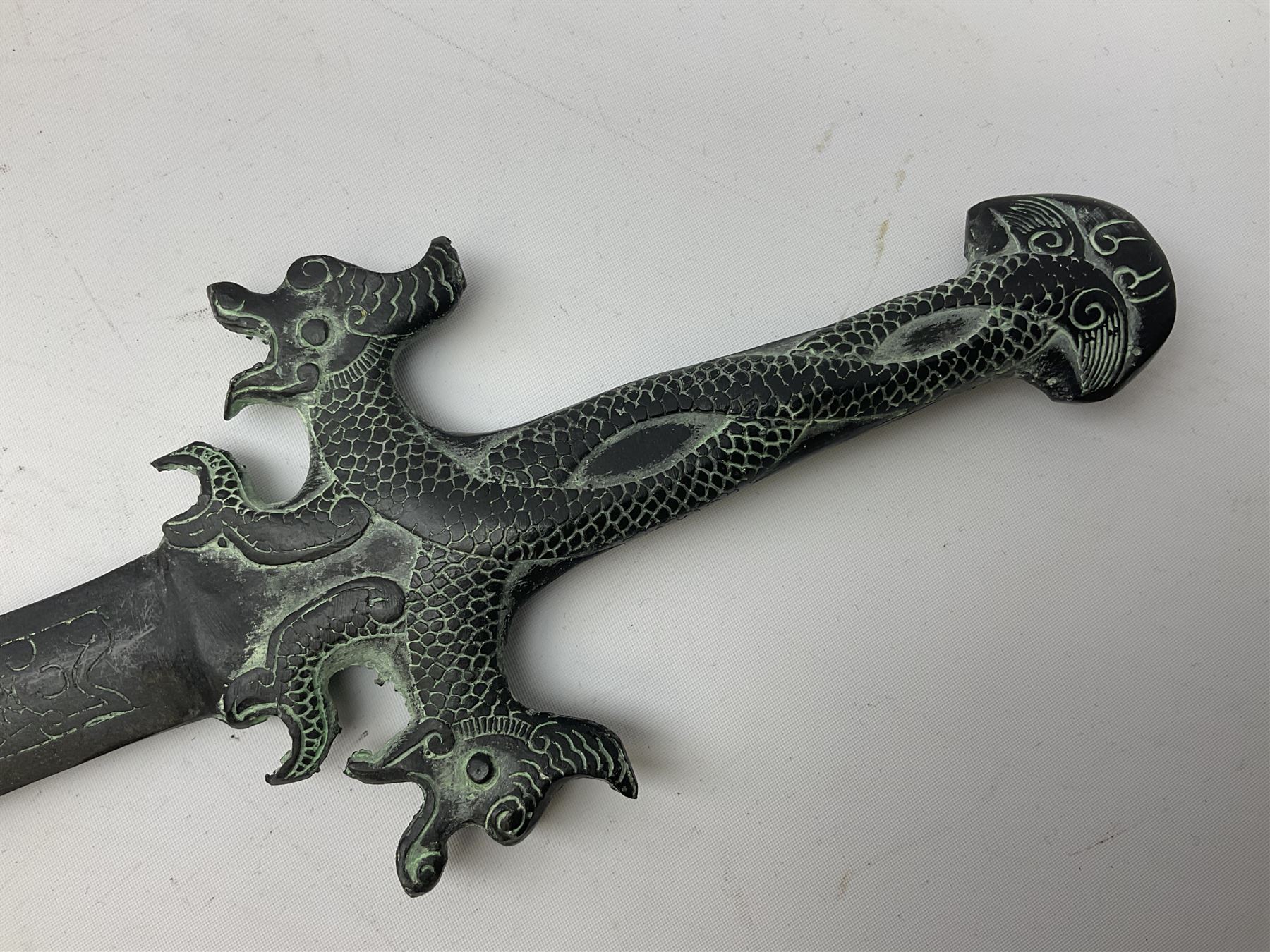 Patinated 'bronze' fantasy dagger, the 26cm blade, hilt and scabbard cast with dragons L50cm overall; hand forged iron spearhead L29.5cm; and a stiletto blade (3)