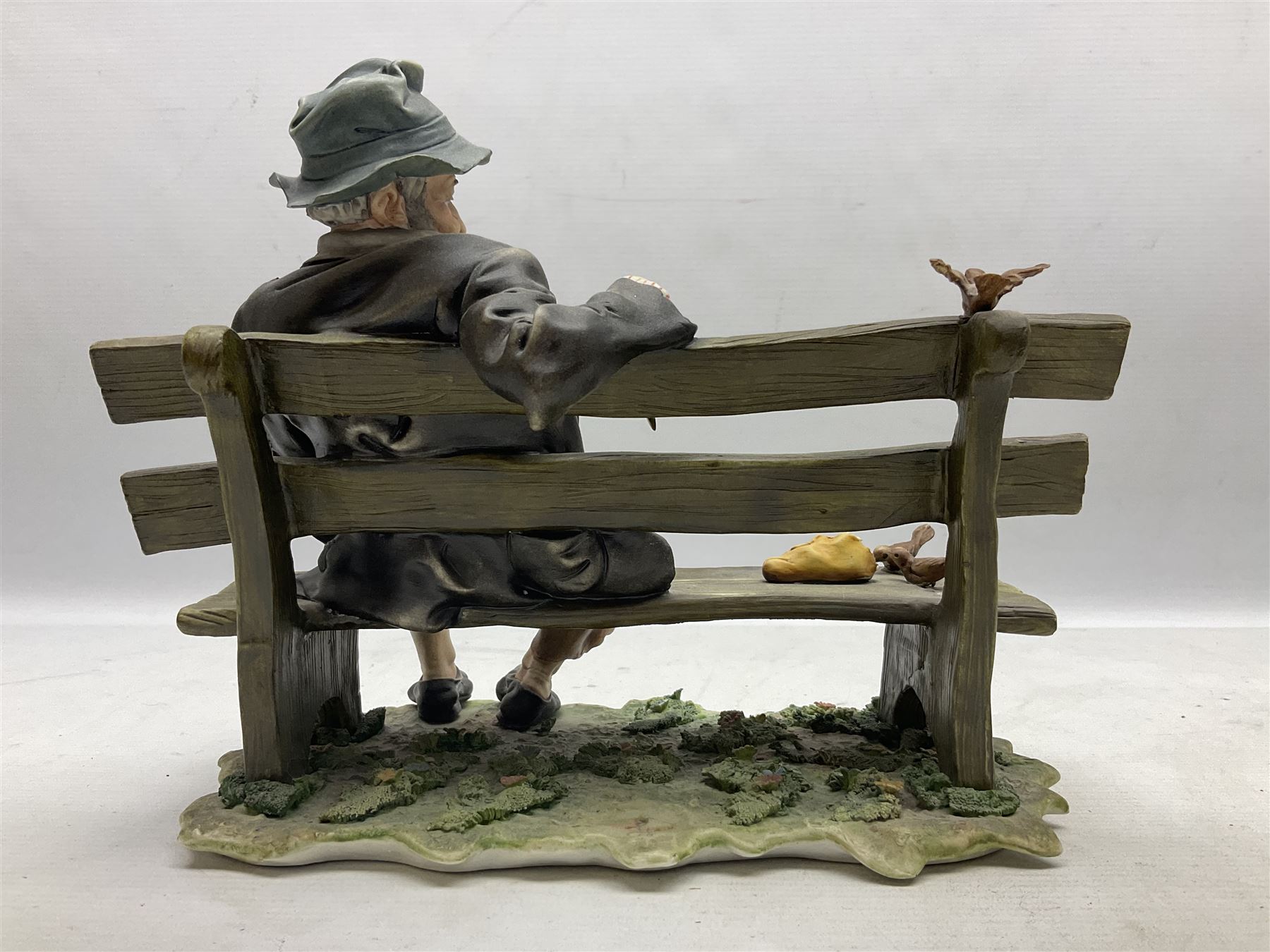 Two Capodimonte figures, comprising The Watchmaker by Curiase and Tramp Seated on a Bench, created by D.Bonalberti, tallest example H24cm