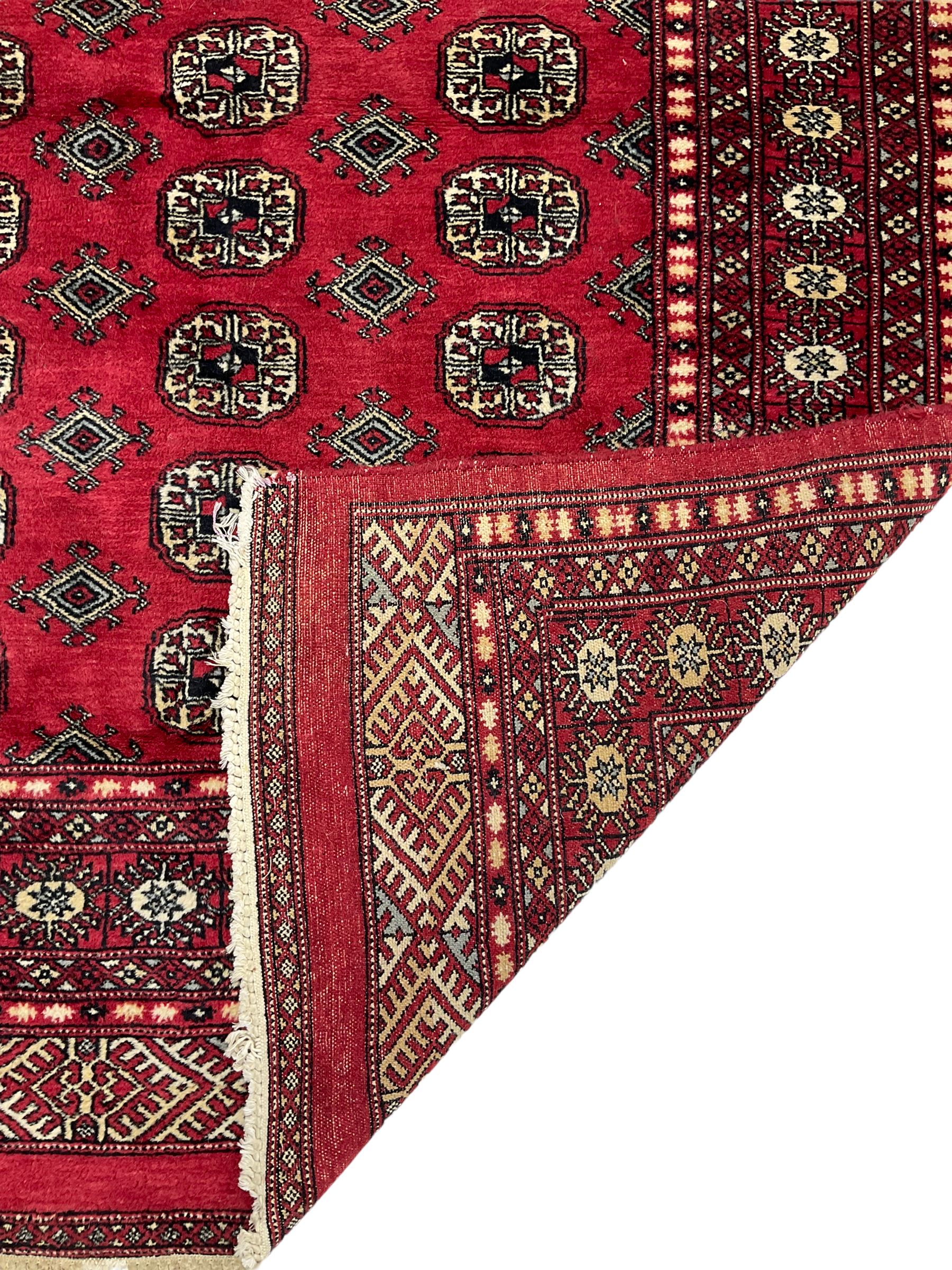 Turkmen Tekke Bokhara rug, red ground and decorated with Gul motifs, repeating multi-band border, signed on corners 