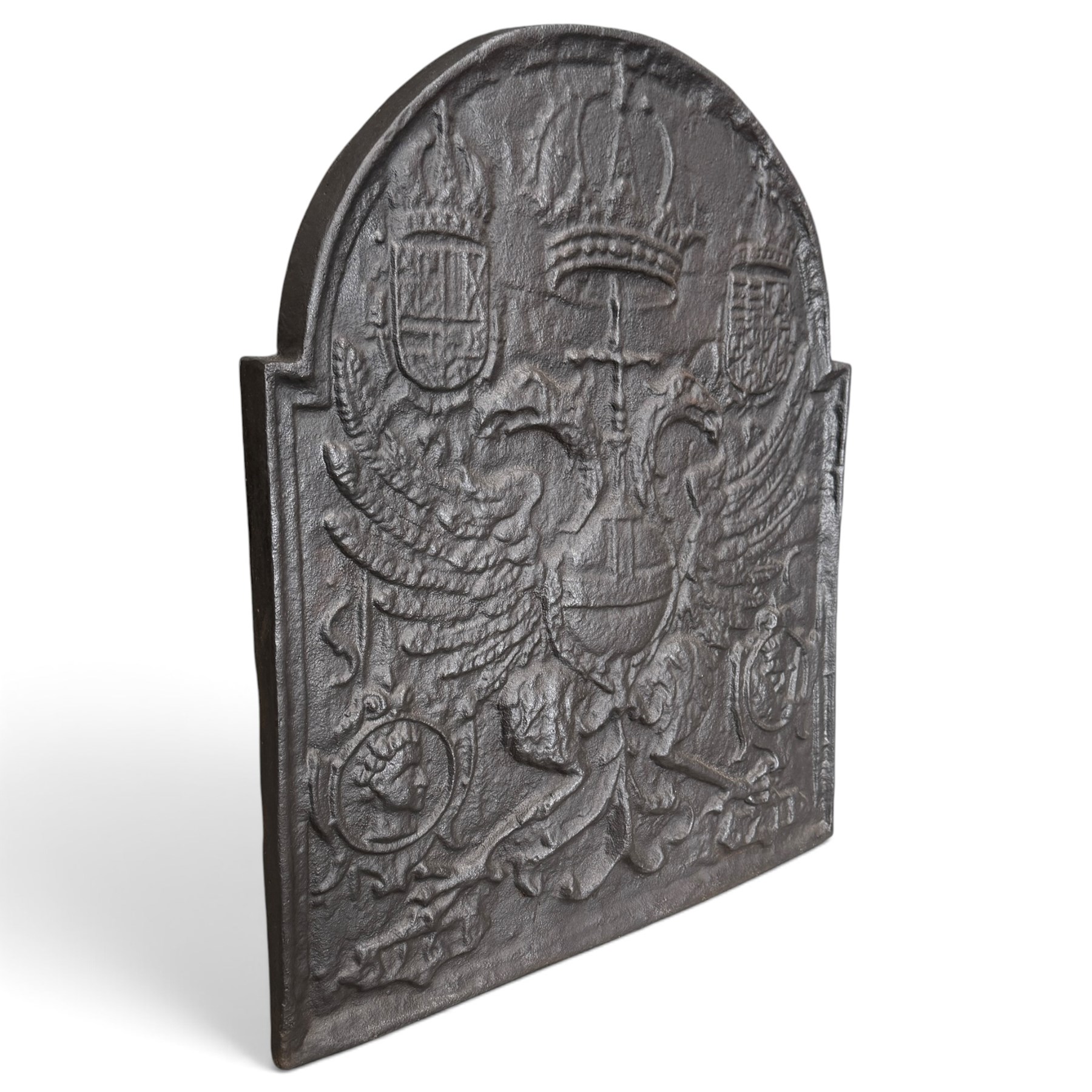 Early 20th century cast iron fireback, after an 18th century Flemish original, the arched plate cast in relief with the crowned Habsburg double-headed Imperial eagle and armorial shields of Charles V, Holy Roman Emperor