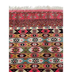 Turkaman red ground rug, the field divided into horizontal rows and decorated with geometric motifs, intricately pattern borders and end panels