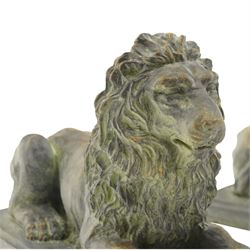 Pair of bronze-effect composition stone recumbent lions, with verdigris-style weathered finish, each raised on rectangular plinth base