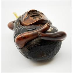 A Japanese carved soft wood inro, modelled as a streching and yawning figure, possibly Daruma, detailed with insect, inset mother of pearl butterfly, and glass eyes, H10cm. 