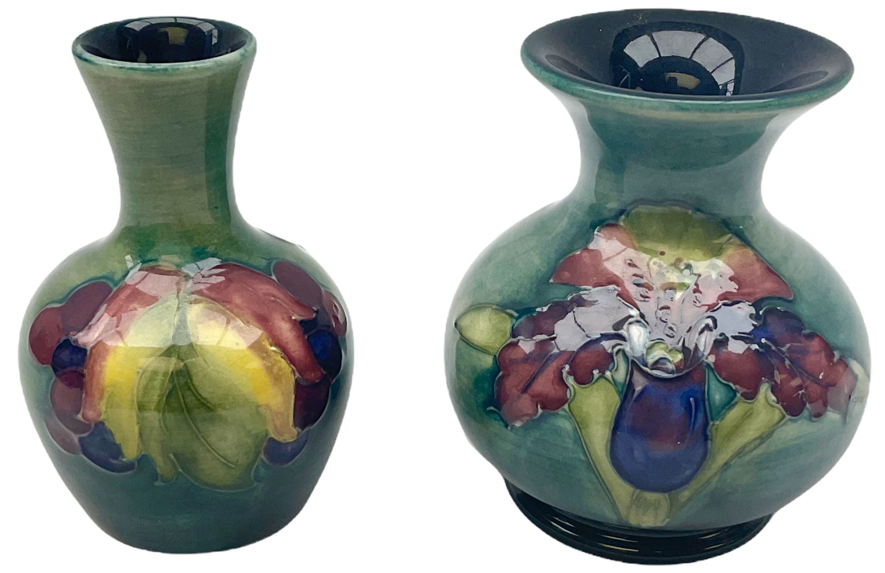 Moorcroft vase, decorated in the Leaf and Berries pattern upon a tonal green ground, together with a further Moorcroft vase, of squat baluster form, decorated in the Iris pattern upon a tonal green ground, each with impressed marks beneath, each H9cm. 