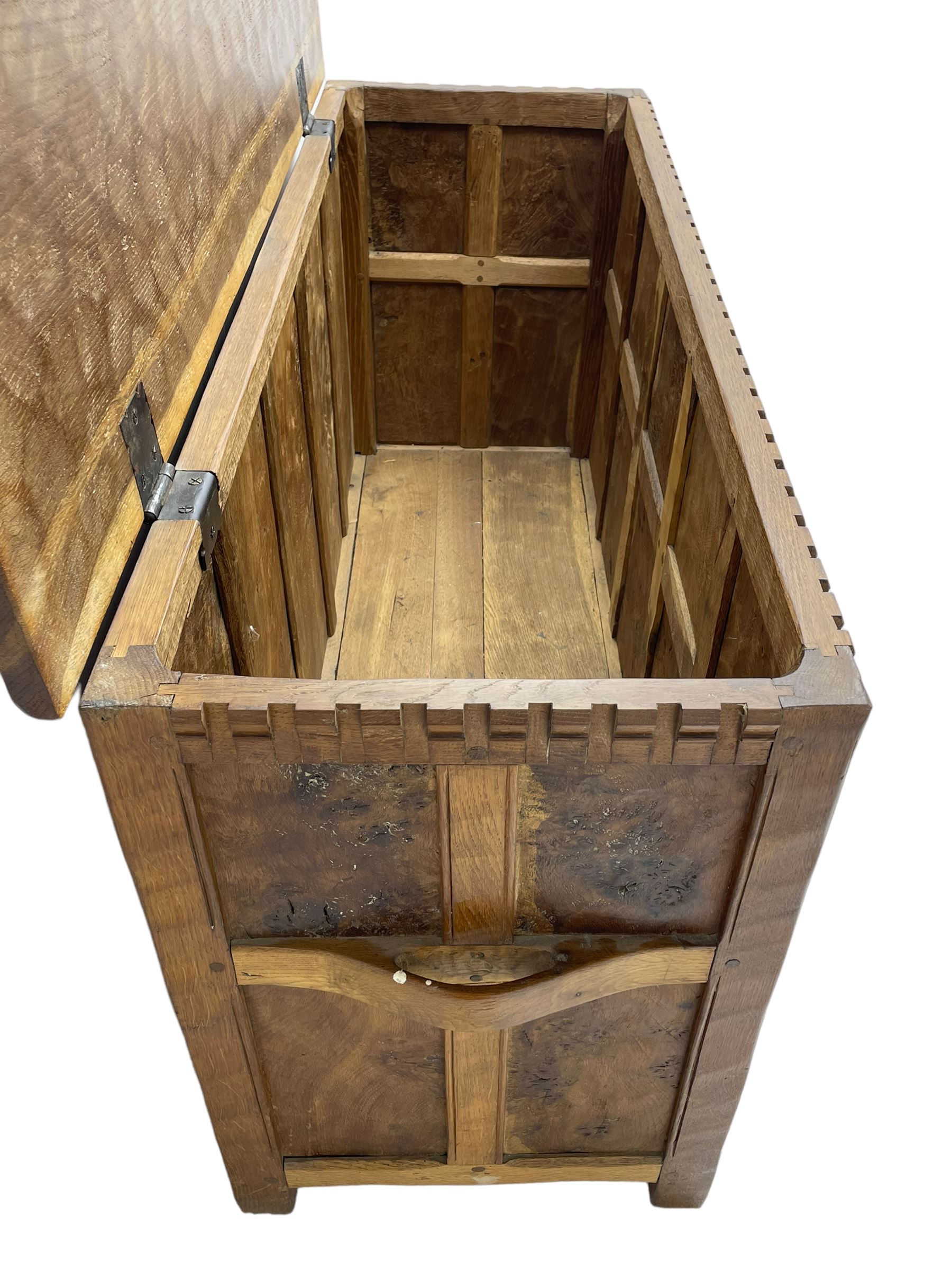 Gnomeman - oak blanket box, all-over adzing, the hinged top over figured and burr panelled front, decorated with carved crenellations and arcade, carved with gnome signature, pierced handles to each end forming the central rail, wrought metal hinges, on stile supports, by Tom Whittaker, Littlebeck, Whitby