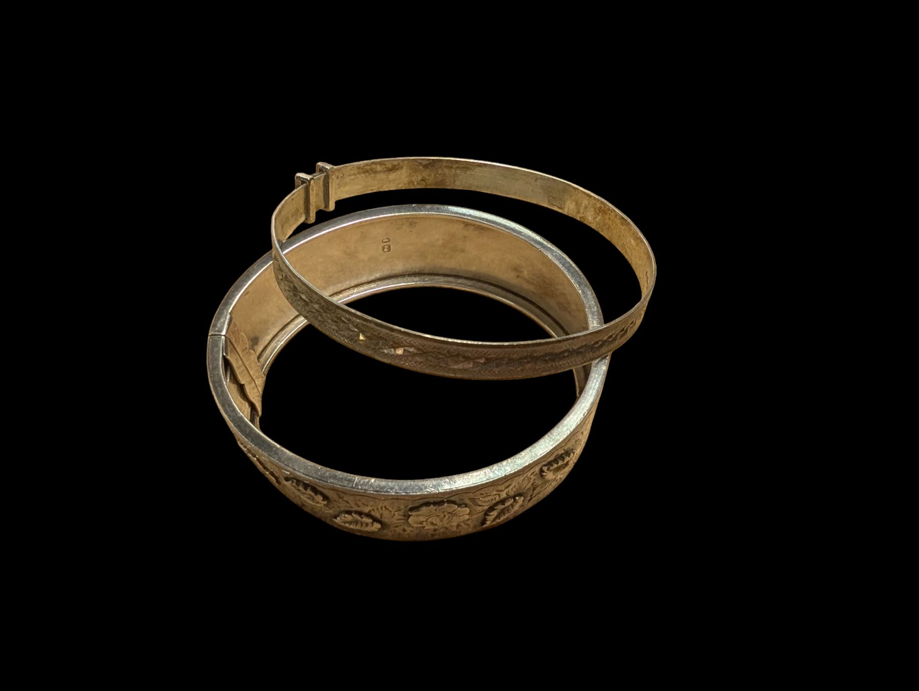 Two silver bangles, including one example with relief floral decoration, hallmarked 
