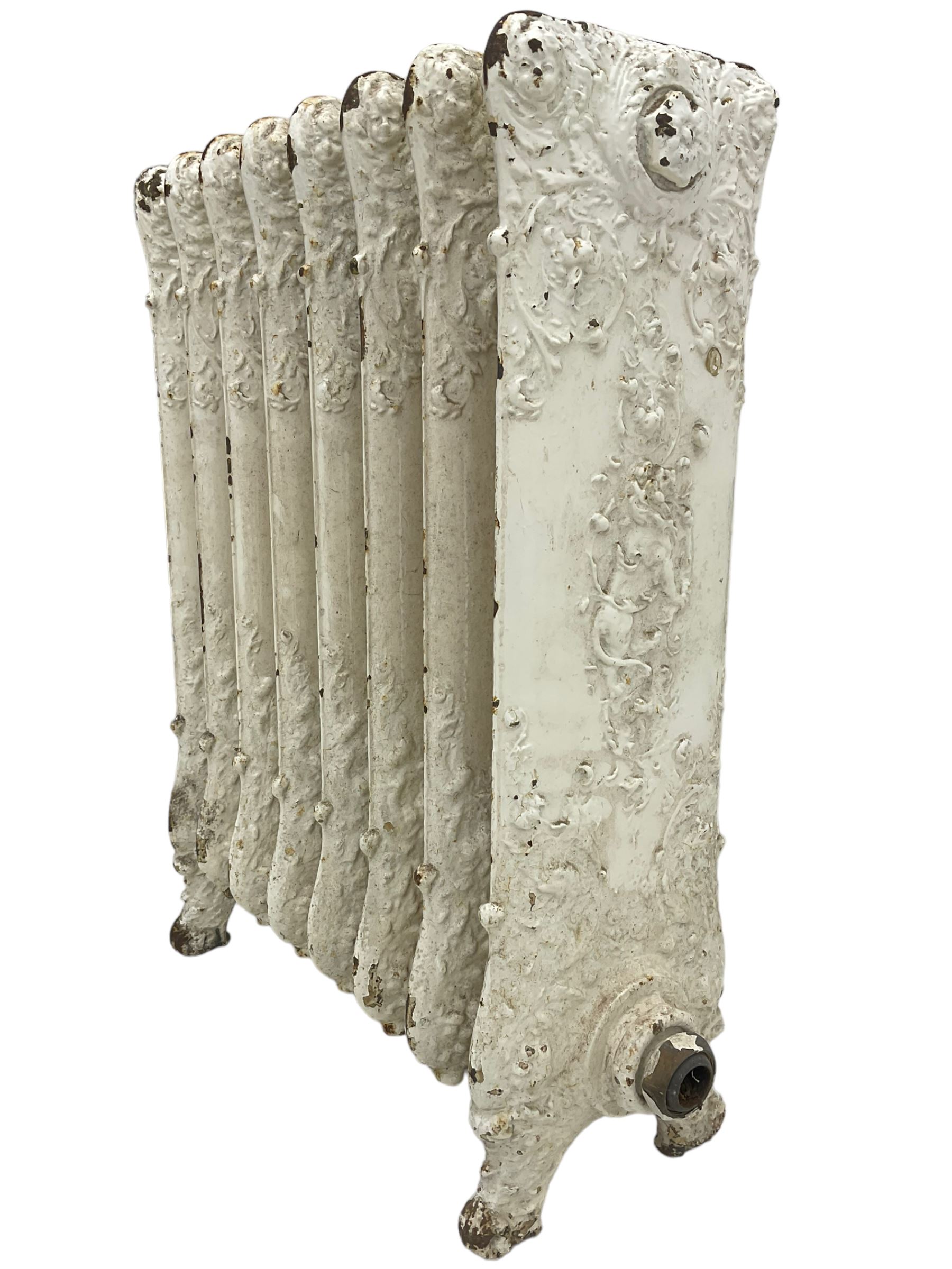 Victorian white painted cast iron radiator, decorated with trailing leafy branches and flowerheads
