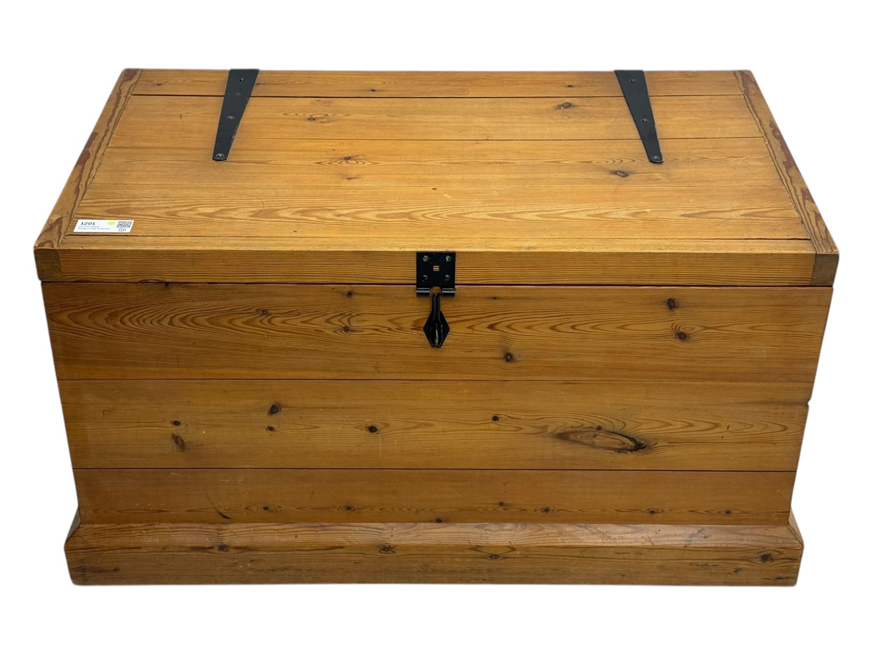 Contemporary polished pine blanket chest, the hinged planked lid with iron strap hinges and clasp fitting, plain boarded sides, fitted with blackened metal drop handles, on a moulded plinth base
