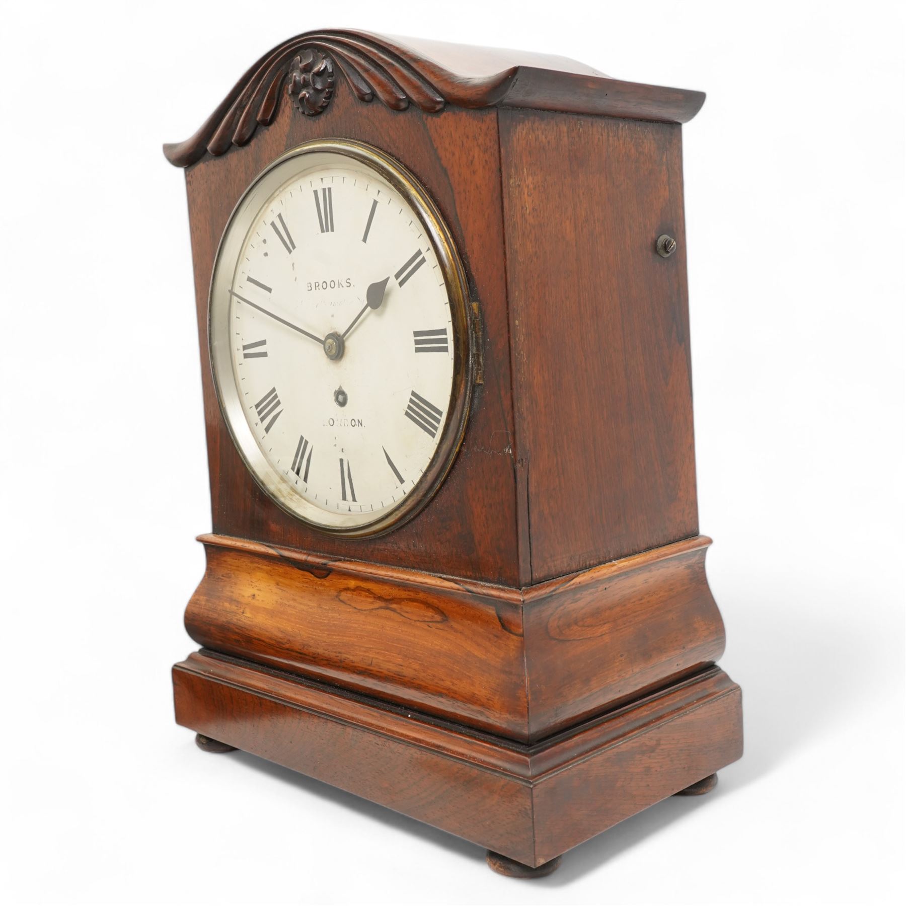 Brooks of London- Regency 8-day rosewood bracket clock c1825, with a serpentine shaped pediment and foliate carving on an ogee stepped base with bun feet, 8