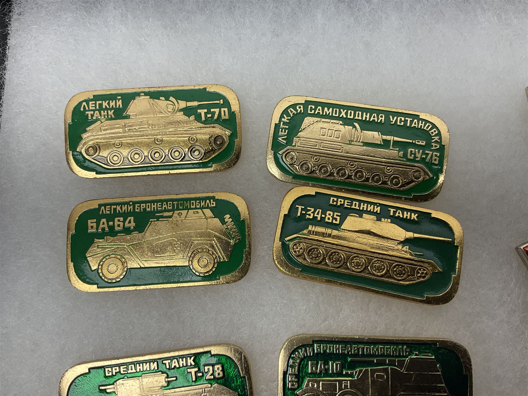 Nineteen Russian Soviet Tank Commemoration badges and medals, in small display case