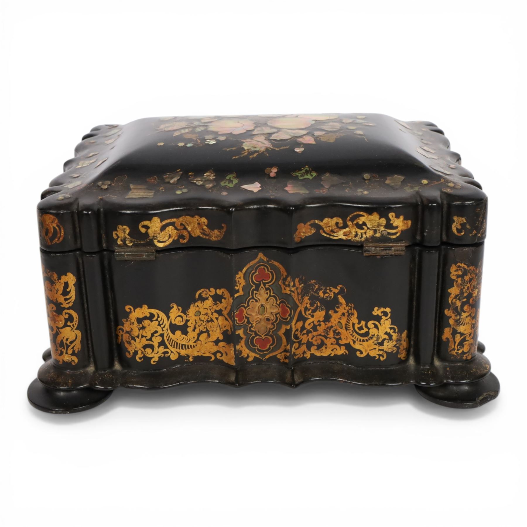 Victorian black lacquered papier-mâché sewing box, of rectangular form with shaped sides, the slightly domed top with inlaid mother of pearl and abalone decoration, the sides with gilt and polychrome painted scrollwork, the hinged cover opening to reveal a fitted interior with lift out tray, H14cm