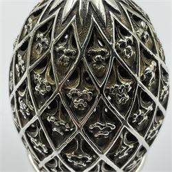 Modern silver limited edition Easter egg, no. 70/500, the openwork lattice body decorated with gilded panels of flower heads, opening to reveal a gilt interior, upon silver stand with three scrolling pad feet, each hallmarked St James House Company, London 1979, height including stand 8cm