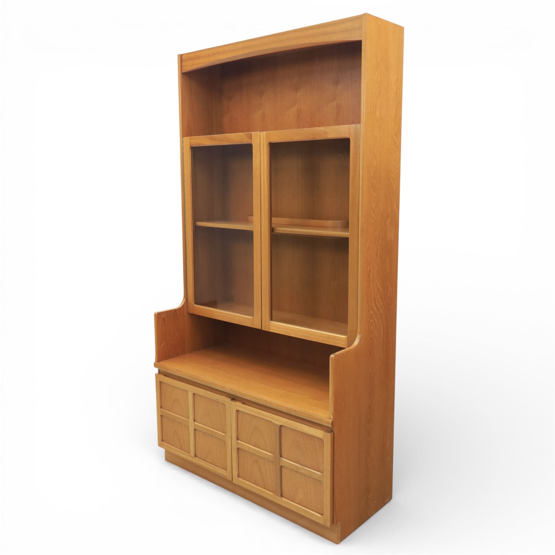 Nathan - teak wall unit, the arched open display recess above a glazed cabinet enclosed by two cupboard doors fitted with internal shelving, the lower section with a recessed serving surface over a pair of signature square panelled cupboard, raised on an integrated plinth base