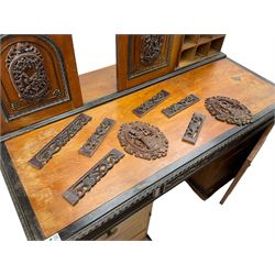 19th century Anglo-Indian teak/camphor twin pedestal desk, raised back fitted with pierced and foliate carved panelled sliding doors, enclosing pigeonholes and correspondence drawers, rectangular top with ebonised banding and moulded edge over a lunette carved frieze, fitted with nine drawers, decorated with carved and pierced mounts