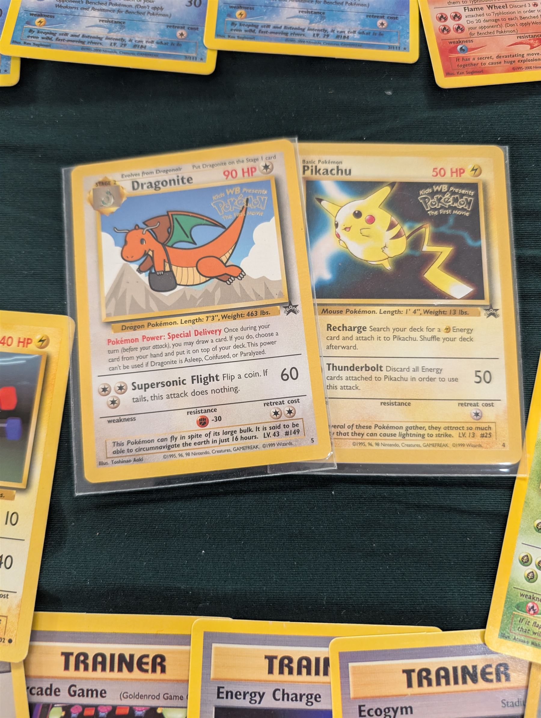 Collection of Pokemon TGC trading cards, including two WB First Movie Black Star promo cards Pikachu no. 4 and Dragonite no. 5, two Ancient Mew Black Star holo promo cards, Gym Challenge Giovanni's Persian 8/132 holo and a small collection WOTC, Neo Discovery and Neo Genesis cards, together with thirty four Bandai Carddass Pokemon cards, including prism Charizard no. 186 and Pokemon Topps cards including holo examples 