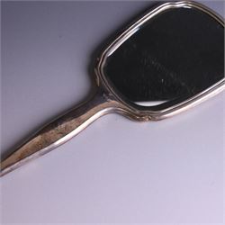 20th Century silver mounted dressing table set, comprising hand mirror, clothes brush, hairbrush and comb holder, each with engine turned and engraved floral decoration, three pieces hallmarked Adie Brothers Ltd Birmingham 1964, the comb holder hallmarked Elkington & Co Ltd Birmingham 1965, contained within a fitted tooled leather case