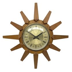 Mid-century teak sunburst wall clock by Anstey & Wilson, modelled with angular teak rays spreading from circular mount with plain brass face with Roman numerals, with battery operated Japanese movement, D45cm