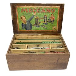 Meccano - wooden box with Set No.5 label to sliding lid, containing two lift-out trays and bottom layer of predominantly red and green sections, wheels, pulleys, rods, tyres etc, carrying handles to either end, L36cm D22.5cm H13.5cm