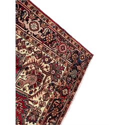 Persian Heriz red ground rug, large medallion decorated with palmettes and Ejder motifs, the border decorated with stylised plant motifs, within floral design guard stripes 