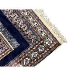 Indo-Persian indigo ground rug, the field depicting a rug with floral medallion and spandrels, enclosed within multiple floral pattern border bands