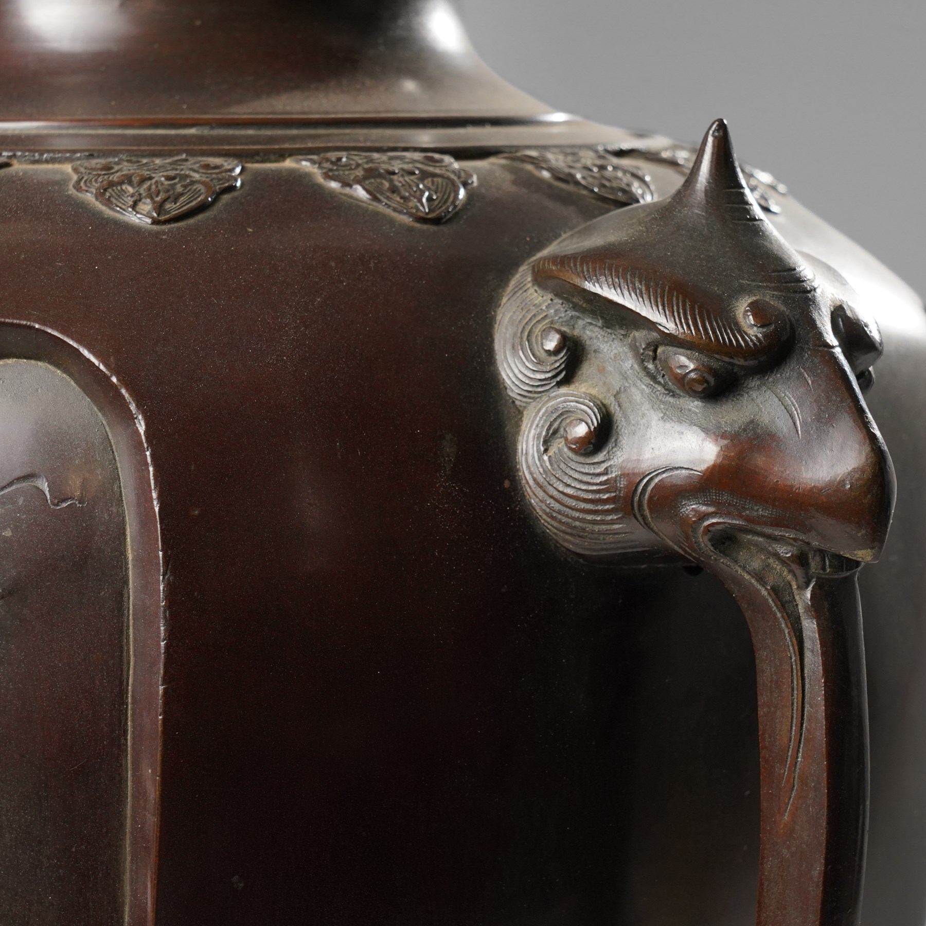Japanese late Meiji period bronze koro and cover, surmounted by an eagle finial and with bird decoration in high relief to each side, twin elephant trunk handles, bearing indistinct character signature to one side, H82cm