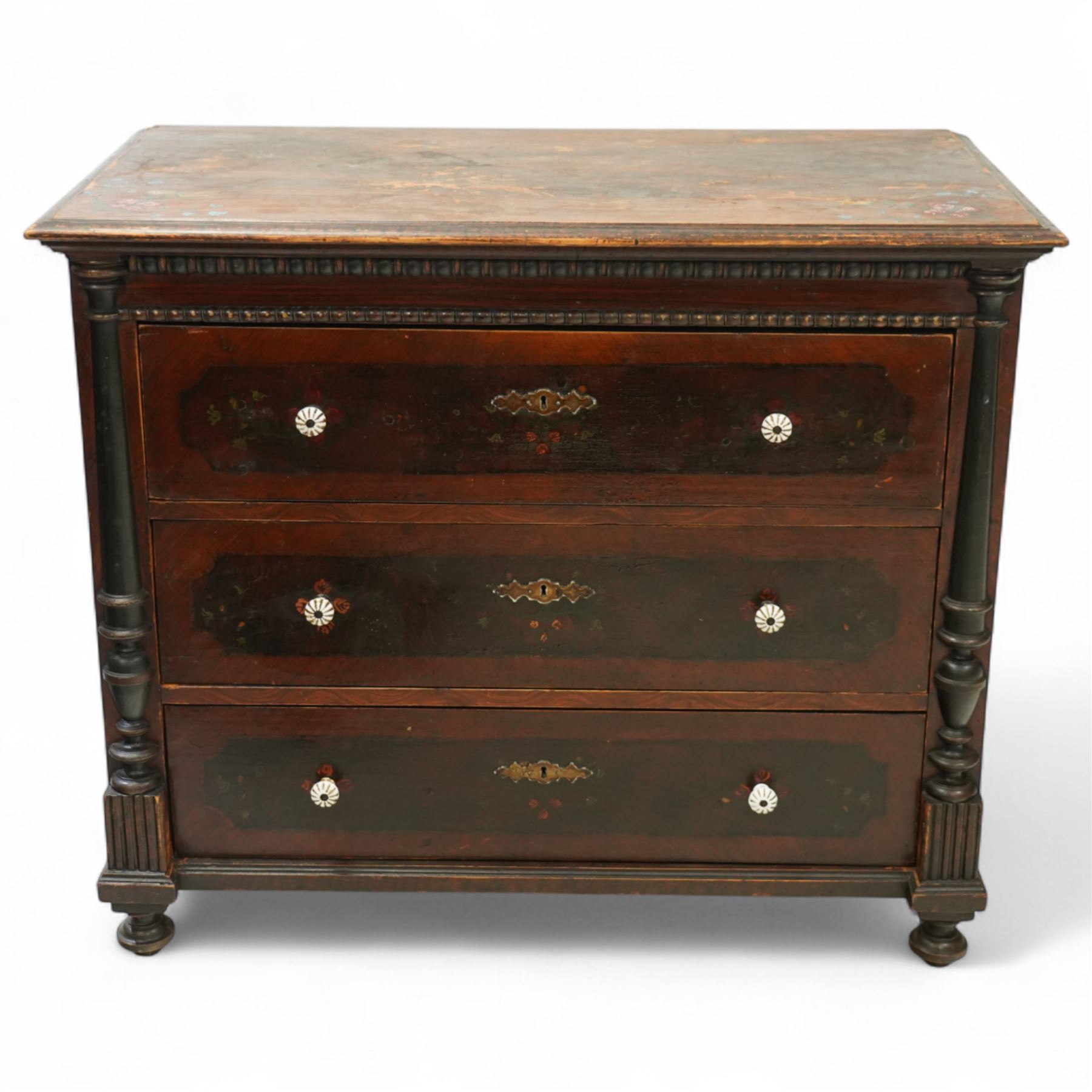 19th century painted pine chest of drawers, the rectangular top with moulded edge and painted floral decoration, above three drawers with later ceramic handles, with half turned column and reeded pilasters, upon turned compressed bun feet  