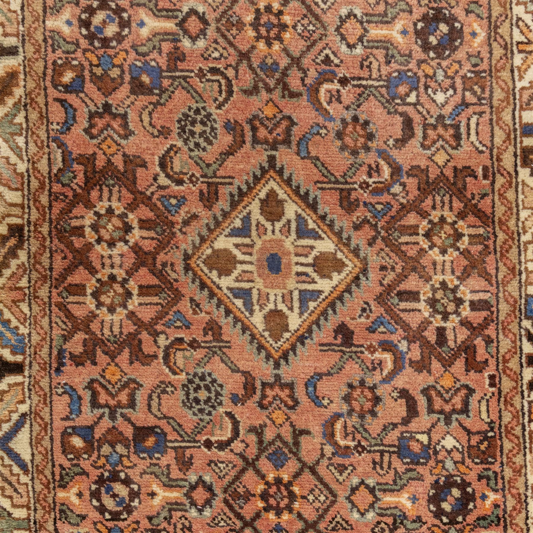 North West Persian Malayer hand-knotted runner, camel pink field decorated with an all-over lattice of Herati design, composed of rosettes and enclosed by angular leaves and stylized fish motifs, principal border of ivory ground decorated with stylized angular vine scroll and geometric palmettes, flanked by narrow guard stripes, with cotton fringe ends 