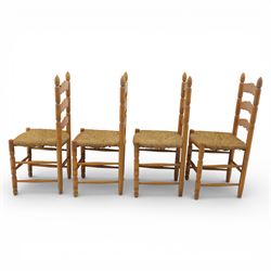 Late 20th century pine farmhouse dining table and four chairs, the rectangular plank top with rounded corners over two frieze drawers fitted with turned knob handles, raised on turned legs, the chairs with shaped ladder backs and turned finials, rush seats in a herringbone weave, on turned supports united by stretchers