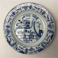 Three Chinese blue and white plates, comprising plate decorated with stylised garden scene with flowers to the centre, bordered with band painted with foliage, grapes and bamboo, together with a pair of blue and white plates each painted with a floral sprig and foliage with insects within foliate and key fret style border, largest D22cm
