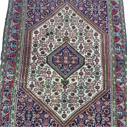 Persian rug, blue ground field with pale lozenge, decorated all-over with Herati motifs and stylised plant motifs