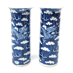  Pair of late 19th/early 20th century Chinese cylindrical vases each decorated with dragons chasing the flaming pearl amongst clouds, underglaze blue four character mark H21cm  