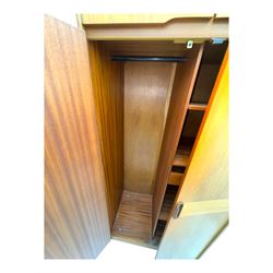 William Lawrence - mid-20th century teak double wardrobe, upper storage section over twin doors featuring recessed handles and contrasting horizontal panel, enclosing hanging rail compartment, towel rail, mirror, shelves and drawer, on plinth base with concealed castors