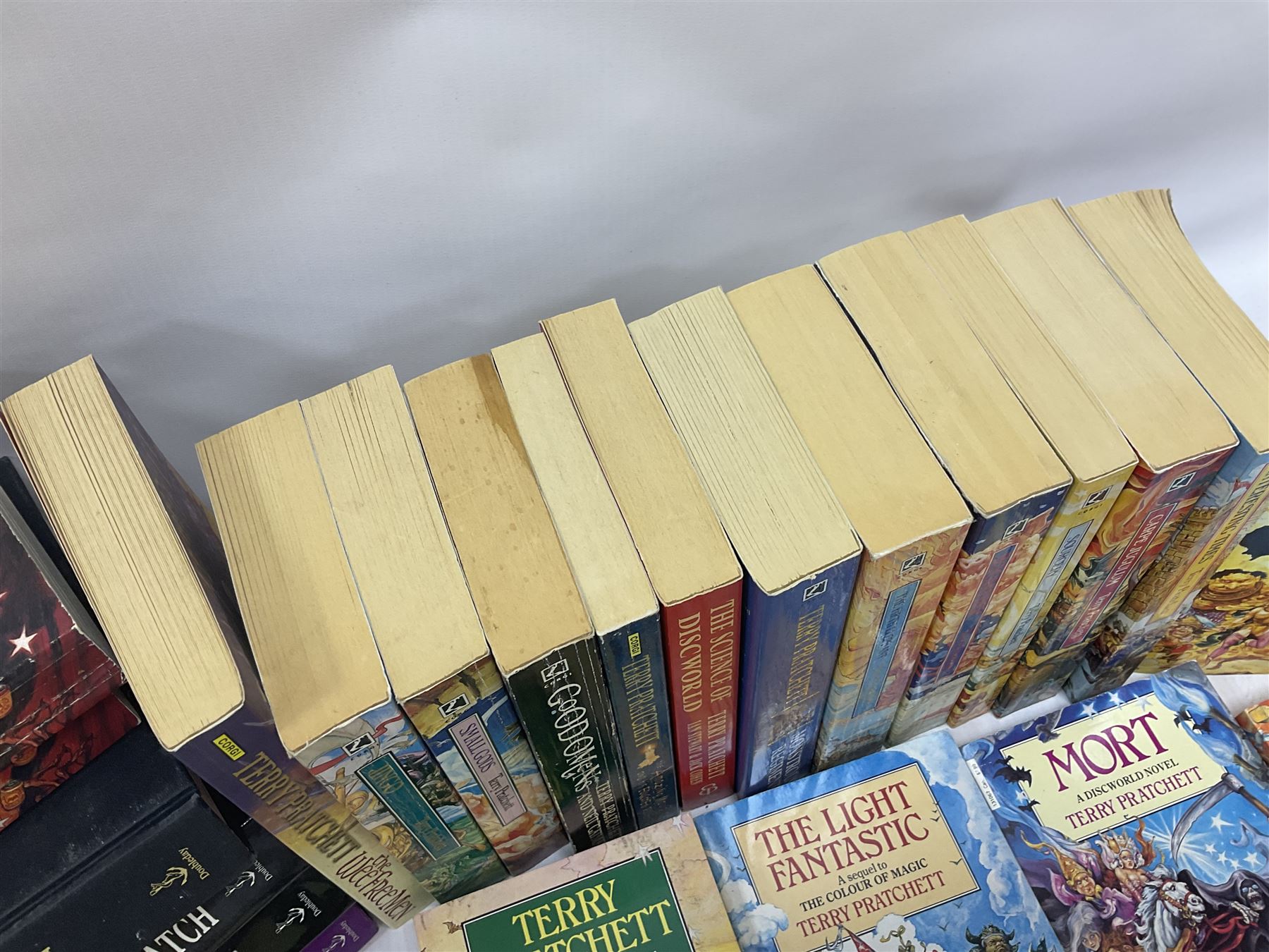 Collection of books by Terry Pratchett, of mostly Discworld interest, to include hardback edition of Going Postal, and further books such as Men at Arms, Sourcery, Small Gods etc 