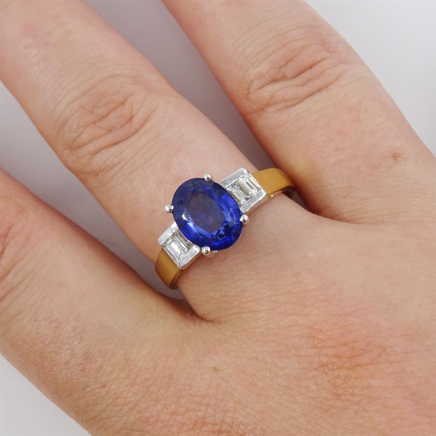 18ct gold tanzanite and diamond ring, single stone oval cut tanzanite of approx 1.75 carat, with two baguette cut diamonds set either side, stamped 750