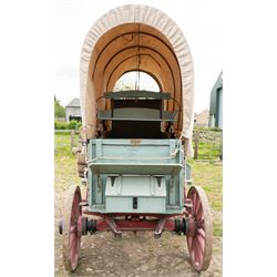 Western Covered Chuck Wagon

A large four wheeled covered wagon of timber construction, painted pale green with red painted wooden spoked wheels and a cream canvas tilt over an arched frame. The wagon has a traditional box body with covered rear compartment, front driving position, underbody turntable steering and iron fittings throughout. Fitted with external equipment details including a side mounted barrel, lidded storage chest, rope tie downs, horseshoe fittings and rear storage box.

Features

• Pale green painted timber body
• Cream canvas tilt over arched frame
• Covered rear compartment
• Front driving position
• Side mounted barrel
• External lidded storage chest
• Rear storage box
• Wooden spoked wheels
• Iron tyres
• Underbody turntable steering
• Rope tie downs
• Horseshoe fittings
• Iron hardware and brackets
• Brass restoration plaque to rear

Dimensions:
Overall length: 335 cm
Width: 170 cm
Height: 275 cm

Wheel Diameters:
Front wheels: 92 cm
Rear wheels: 112 cm

Seating:
Driver: 1
Passenger: Rear covered compartment