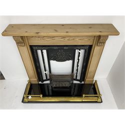Cast metal fireplace in pine surround, decorated with foliate scrolls and flower heads, black granite hearth and brass fender, together with optional gas fire fitting