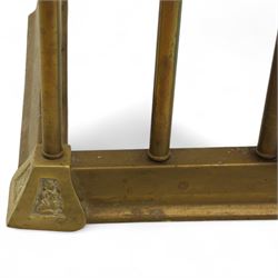 Late Victorian brass and cast iron club fender, burgundy leather buttoned seat pads, secured by bar uprights at the front and back, and a cross stretcher held in place by further bar uprights on a chamfered platform base, circa 1890, internal base dimensions 127cm 