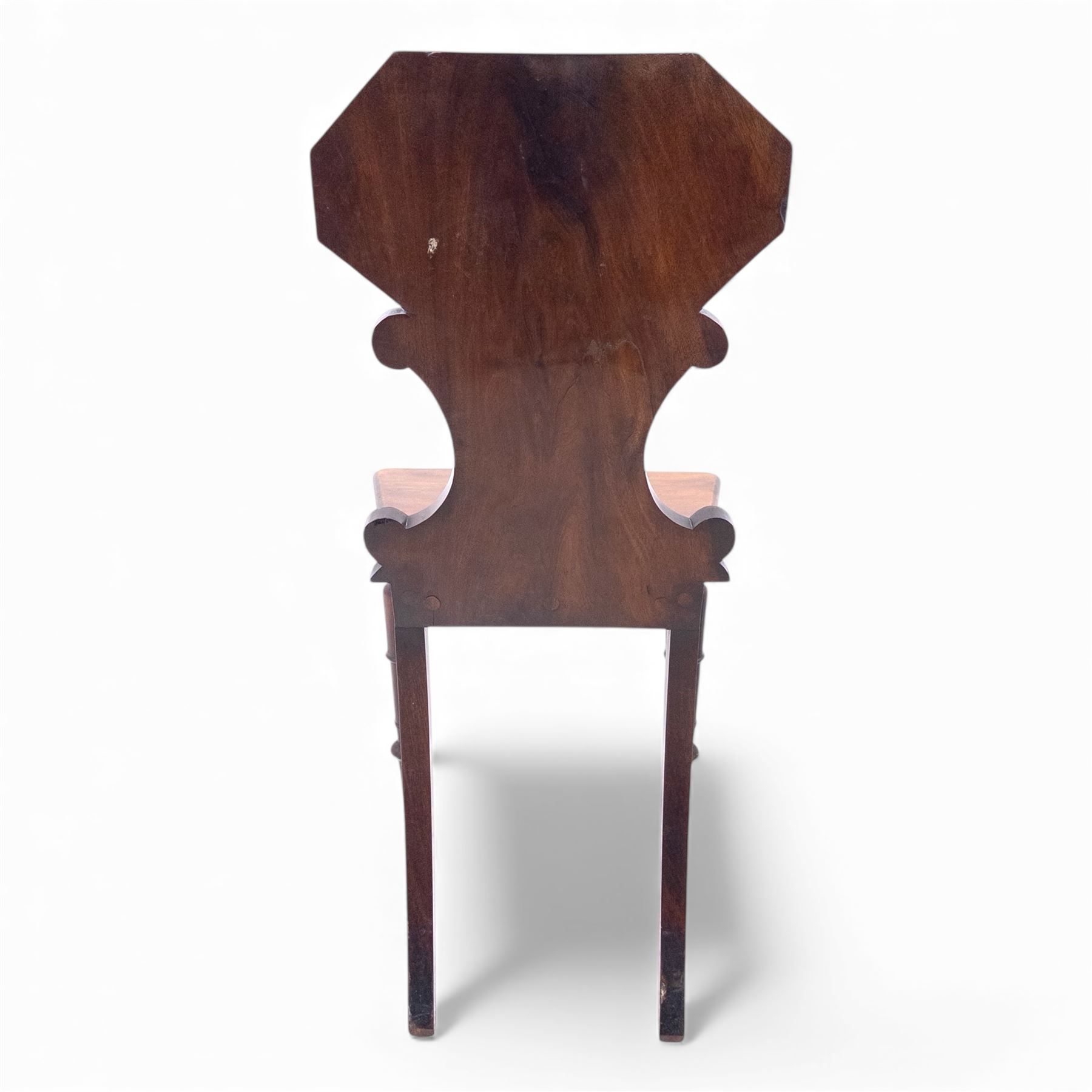 Pair of 19th century mahogany hall chairs, each with shaped octagonal backrest featuring a recessed cartouche panel, serpentine supports and moulded seat, raised on turned front legs