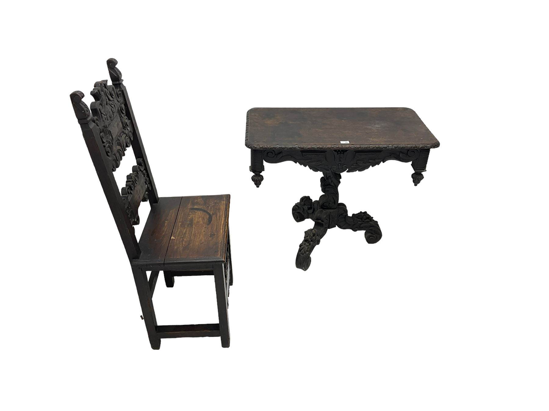 Late 19th century Gothic revival carved oak pedestal table, rectangular top with carved edges, apron carved with trailing foliate and scrolled decoration, heavily detailed column with scrolling decoration and floral carvings, the tripod base with cabriole supports carved with flowerheads (93cm x 53cm x 75cm; Late 19th century carved oak hall chair, panelled back rails with extending scroll decoration (51cm x 40cm x 116cm)